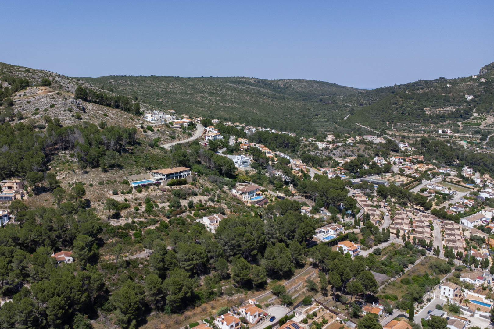 Aerial perspective of the elevated Alcalalí hillside, showcasing the residential plots integrated into the natural landscape with expansive views over the Jalón Valley.