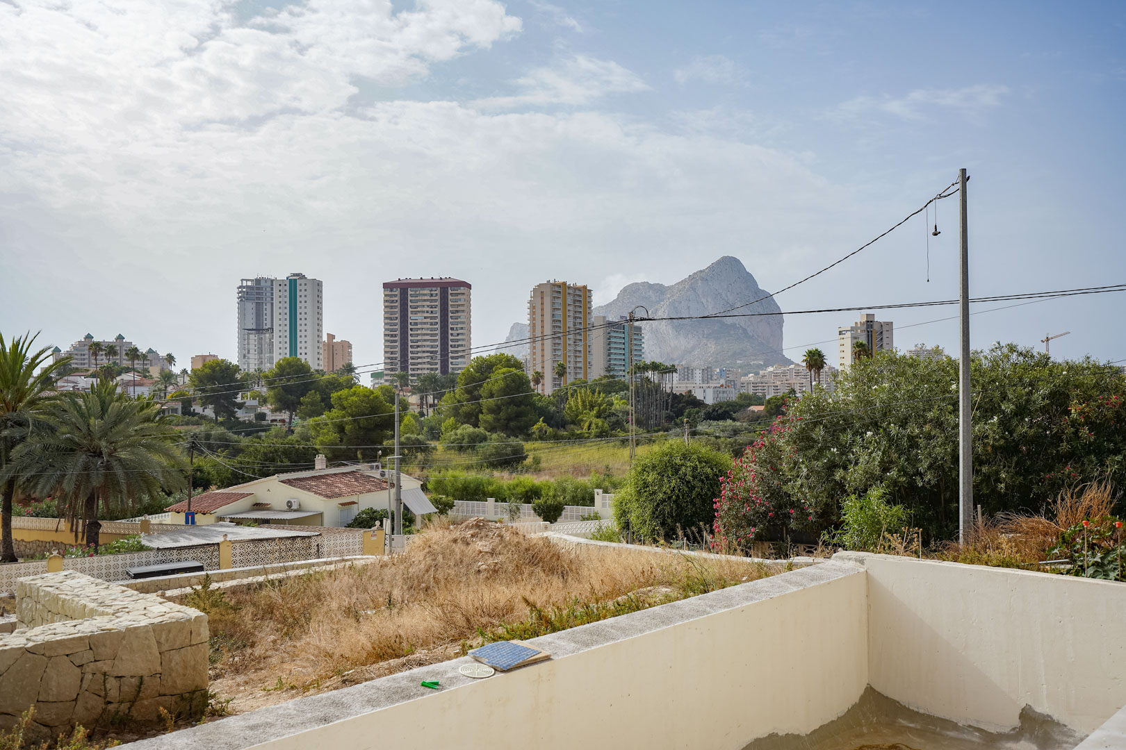 Clear views of the Peñón de Ifach and Calpe's skyline from the elevated plot, showing the surrounding Mediterranean greenery and urban landscape.