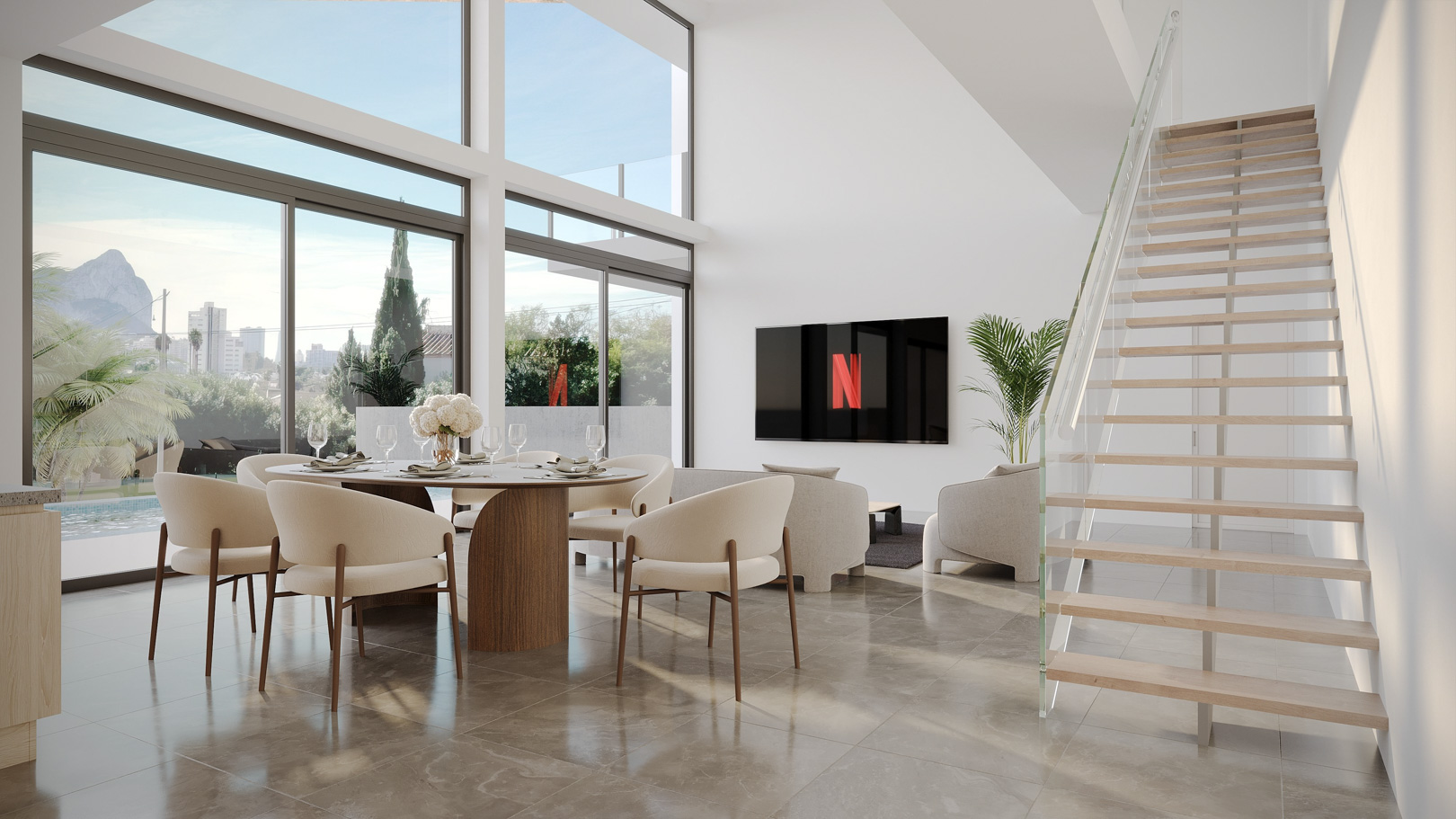 Double-height living area with floor-to-ceiling windows, views of Peñón de Ifach, polished stone floors, and a modern floating staircase with glass railing.