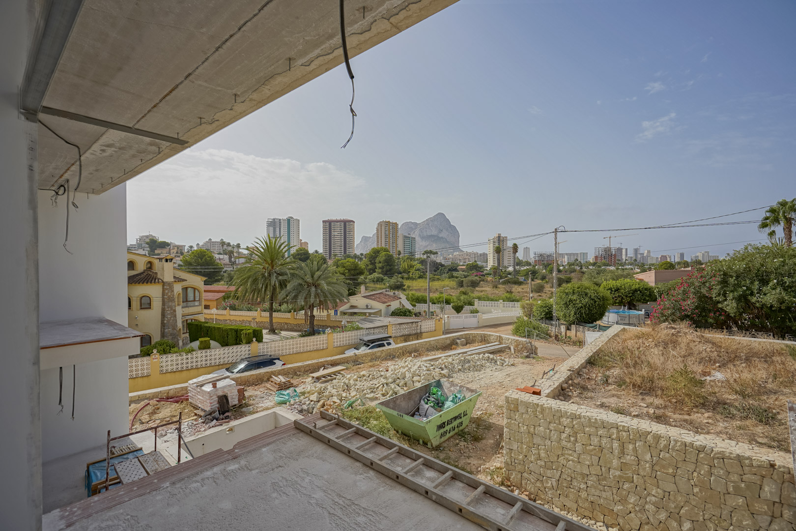 Panoramic view from the upper floor under construction, showcasing the Peñón de Ifach rock and Calpe skyline overlooking the future garden area.
