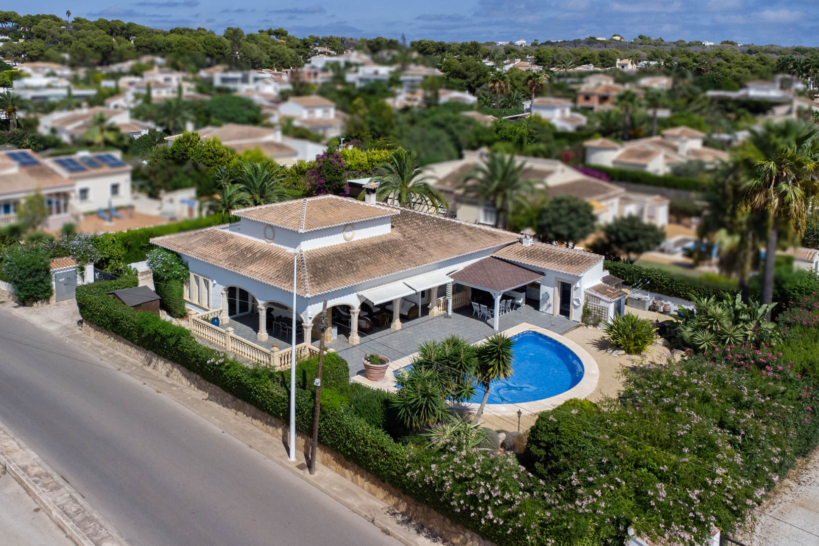Aerial view of villa with private pool, covered terrace, and mature garden in Costa Nova, Jávea.