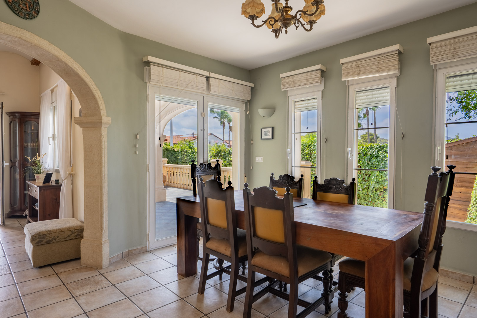 Dining room with solid wood table and classic chairs, with access to the outdoor terrace.