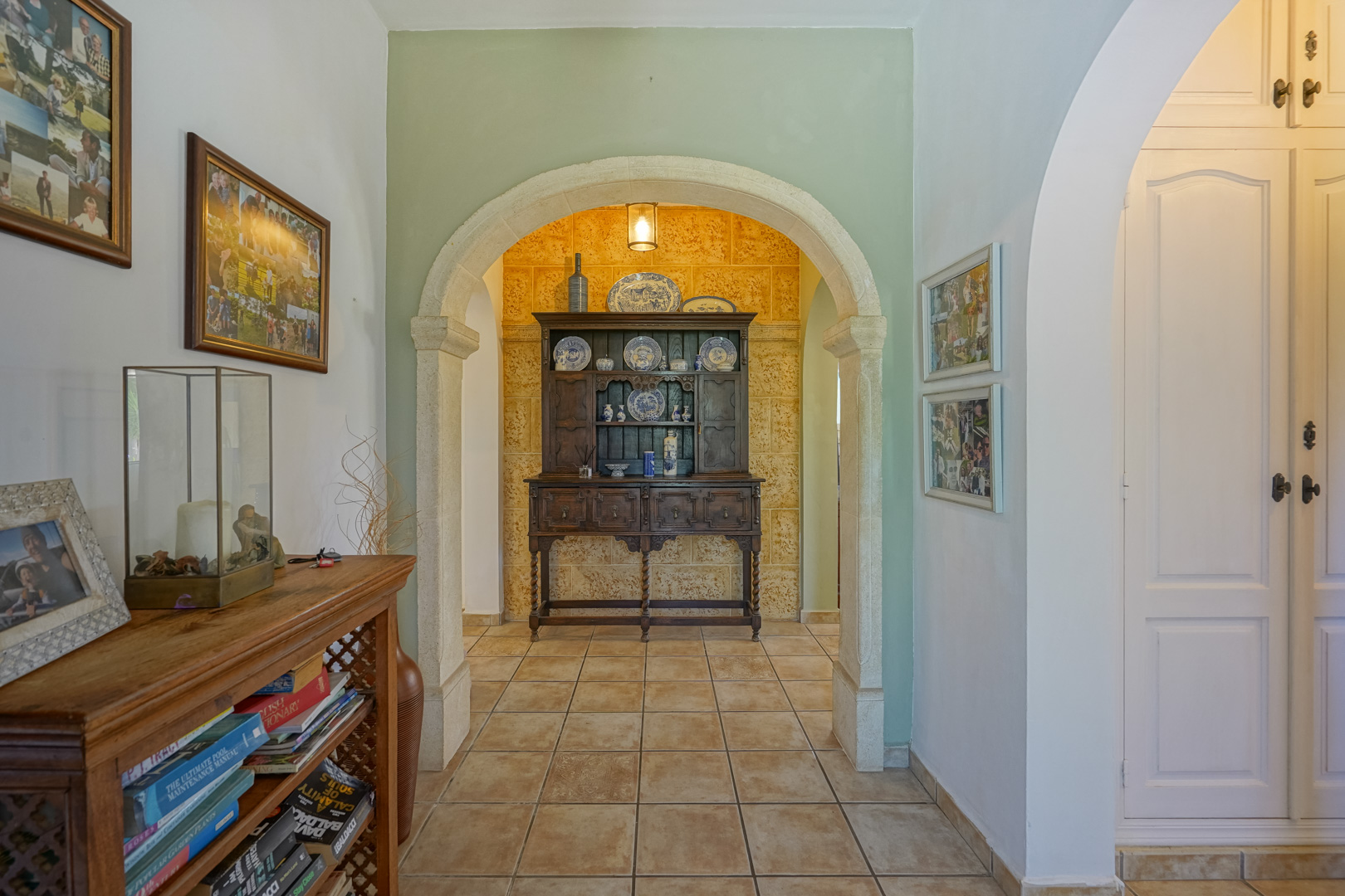 Hallway detail with stone archway and classic dark wood furniture.