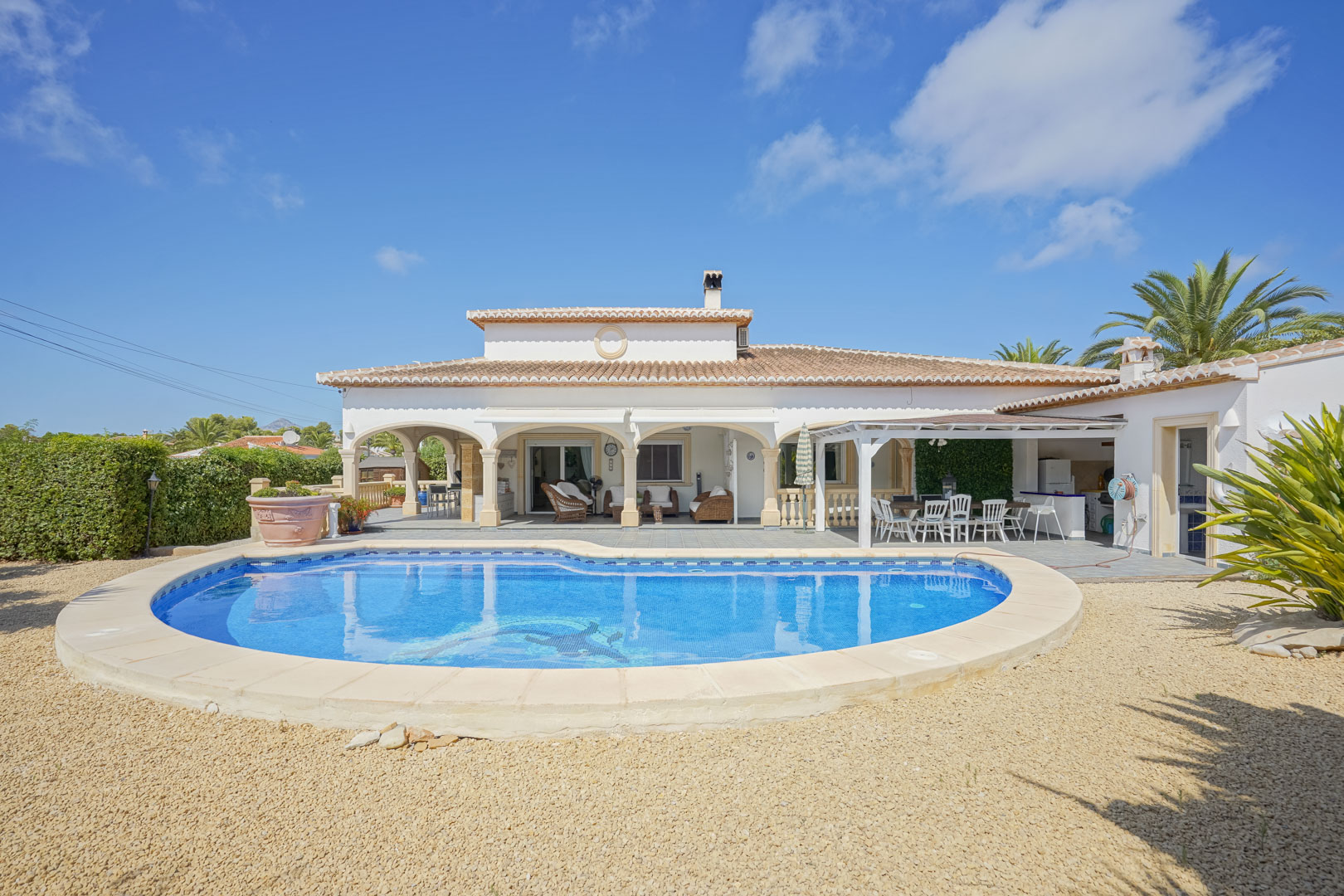 View of the tiled pool and arched covered terrace of a villa in Jávea.