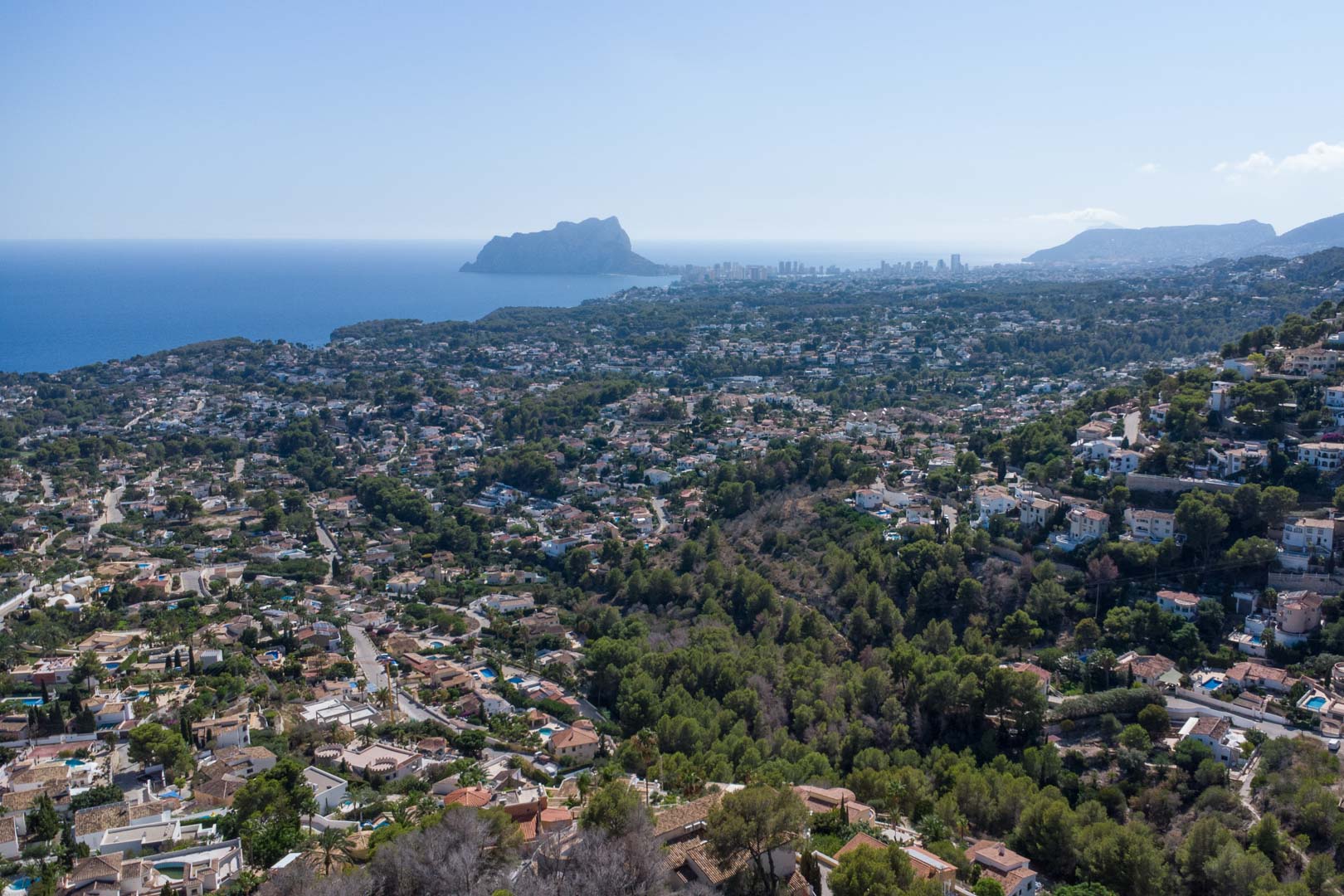 Panoramic aerial view of the Moraira and Calpe coastline, featuring the Peñón de Ifach landmark and residential hills overlooking the Mediterranean Sea.