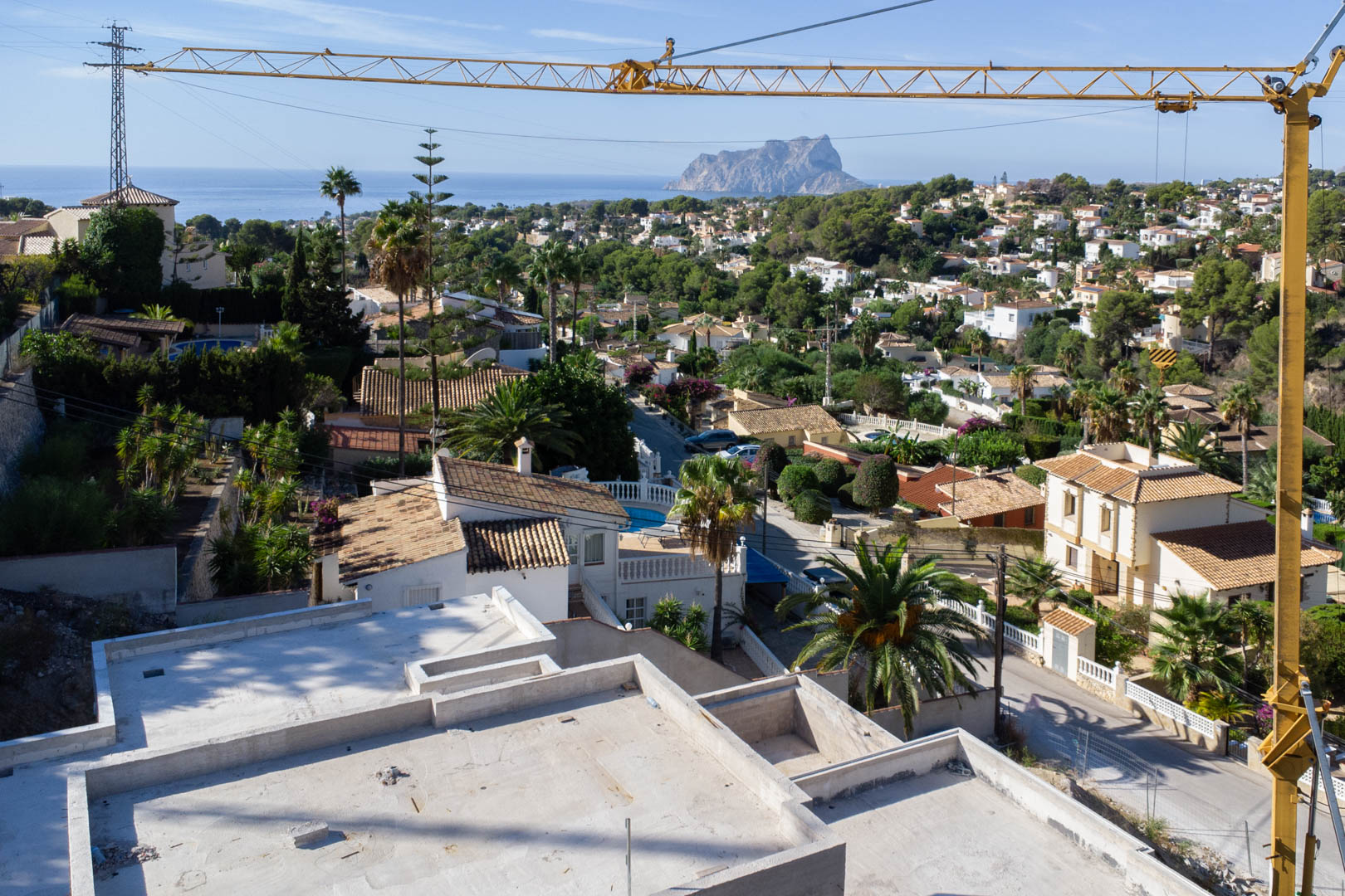 Panoramic views from the villa's upper level under construction, overlooking the San Jaime neighborhood towards the Mediterranean Sea and the Peñón de Ifach.