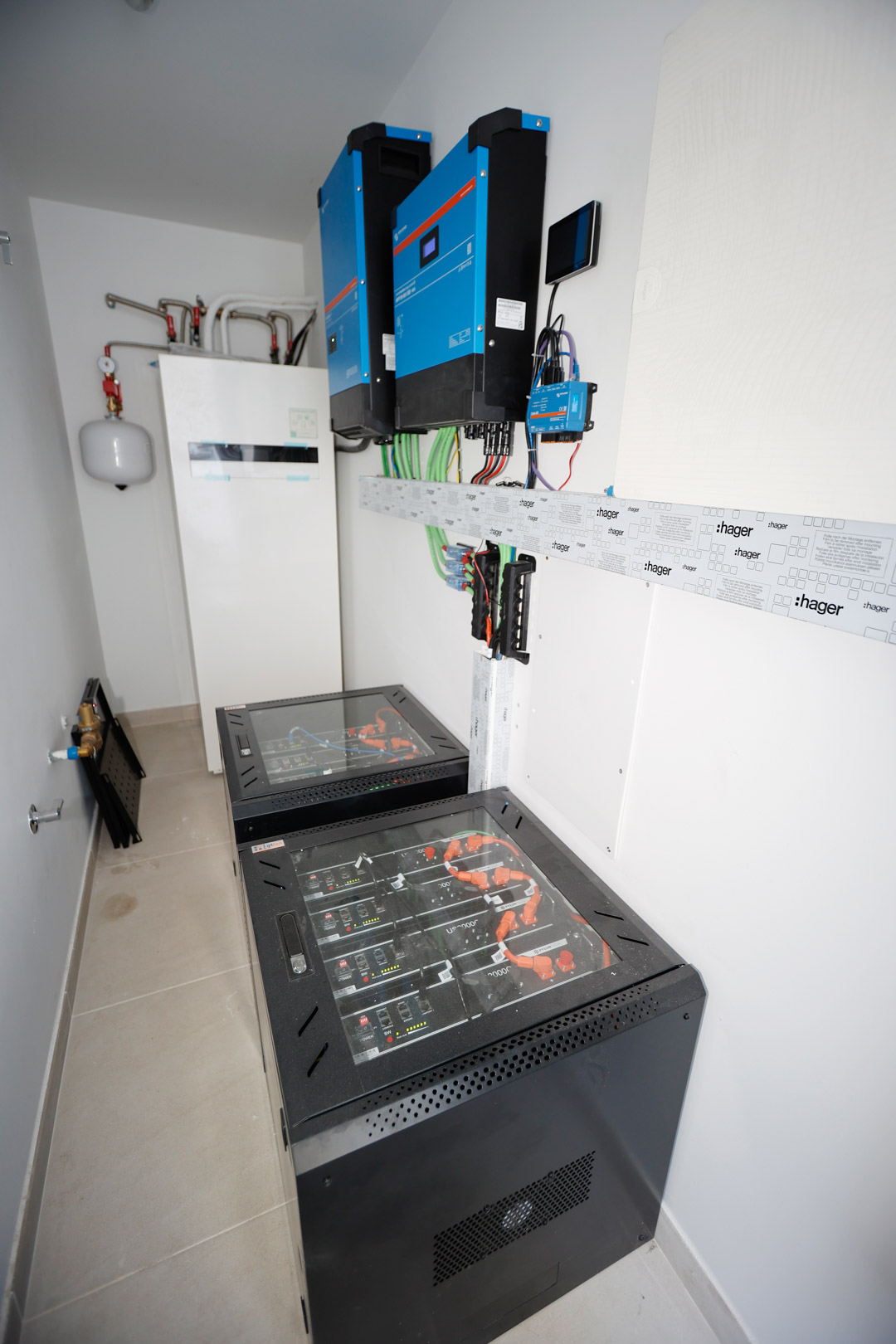 Technical room showcasing the 10 kW solar installation, Victron inverters, and 19.2 kWh lithium battery racks for sustainable energy management.