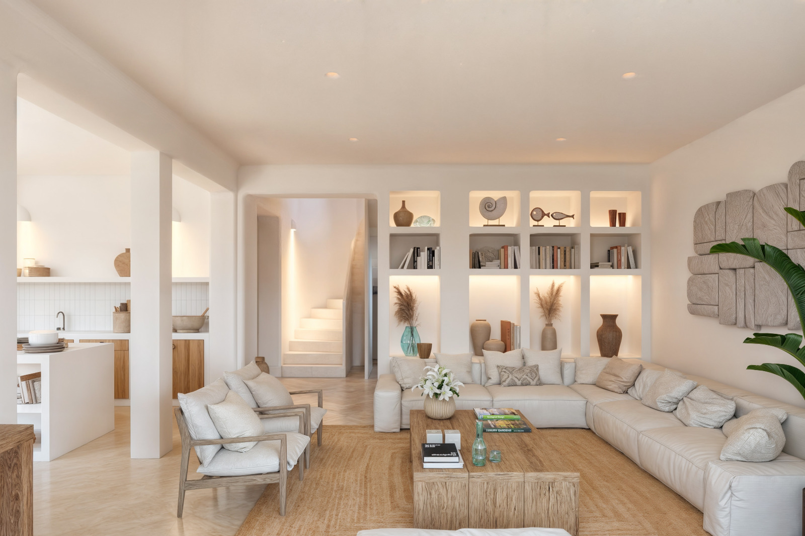 Ibicencan-style living room featuring built-in illuminated shelving, a large modular sofa, and a solid wood coffee table. The open layout connects to the kitchen and staircase.