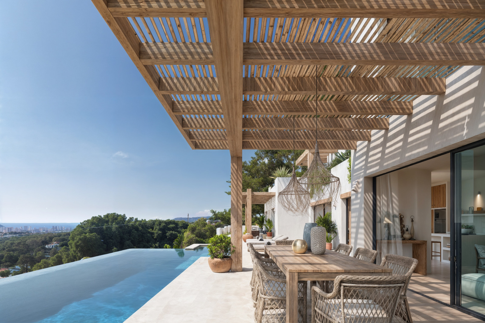 Outdoor terrace featuring a wooden slatted pergola, dining area, and infinity pool with panoramic views of the Mediterranean coast and greenery.