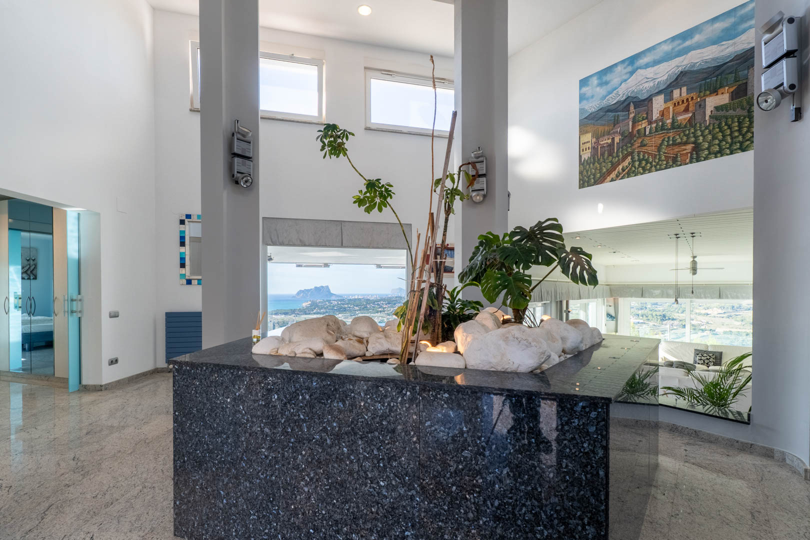 Interior detail with polished granite countertop, plants, and coastal views from expansive windows.