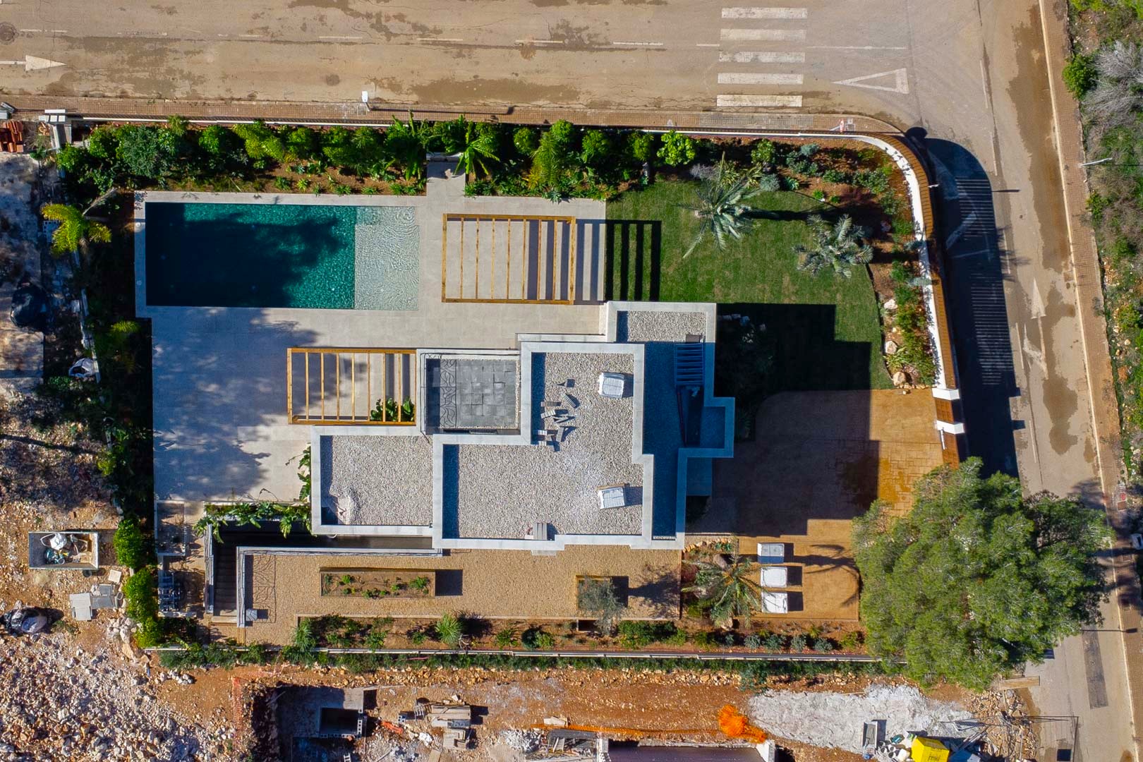 Aerial top-down view showing the villa's layout, the Bali-style saltwater pool, wooden pergolas, and the landscaped Mediterranean garden on a level plot.