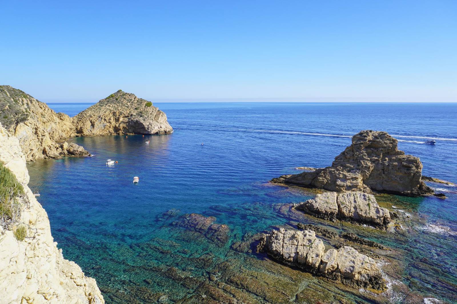 Panoramic view of the Jávea coastline featuring crystal-clear turquoise waters and rugged cliffs, located just minutes from the property.