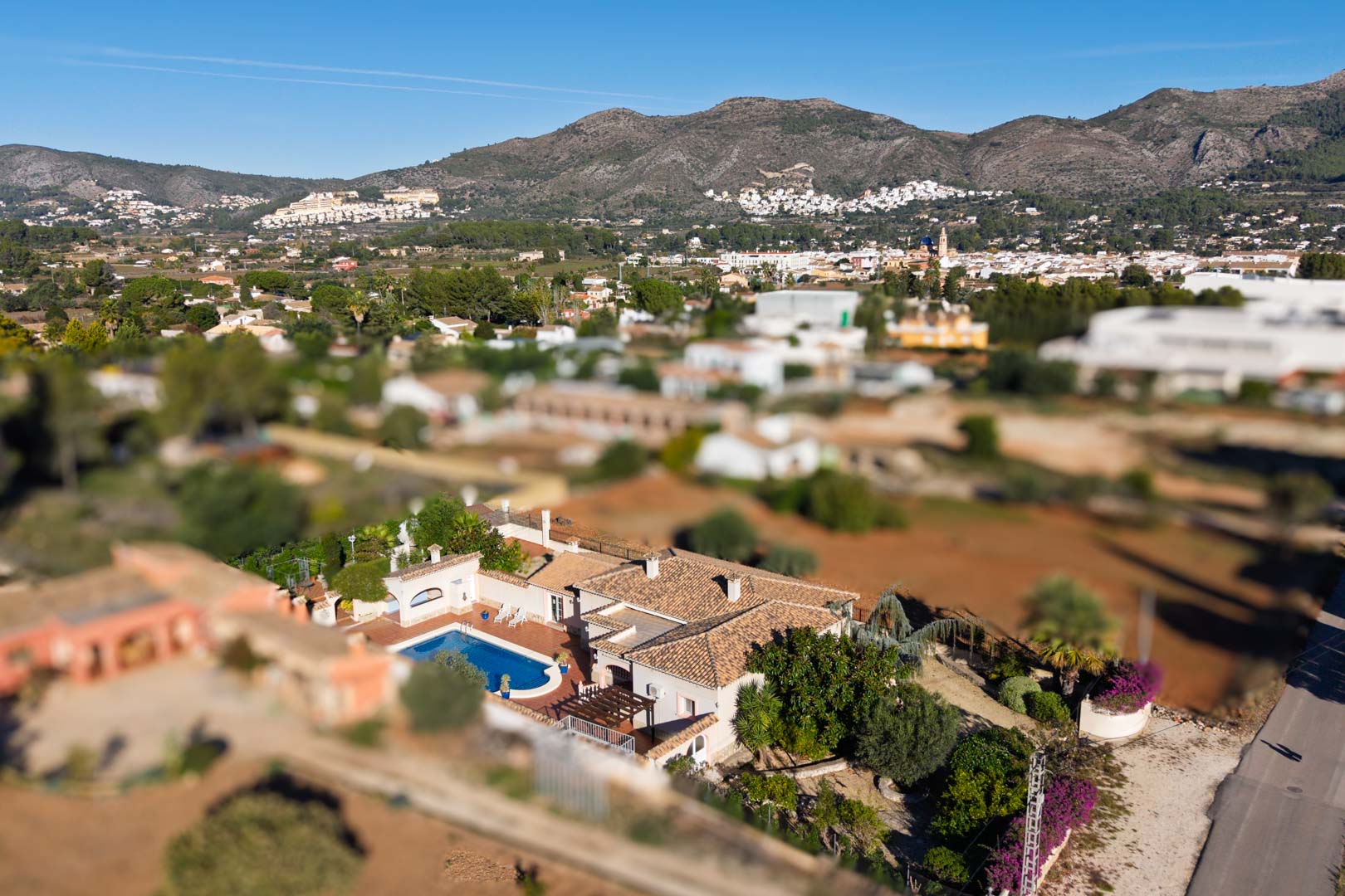 Aerial perspective of the Mediterranean villa showing the private pool, tiled roof, and expansive views of the Jalón Valley and mountain range.