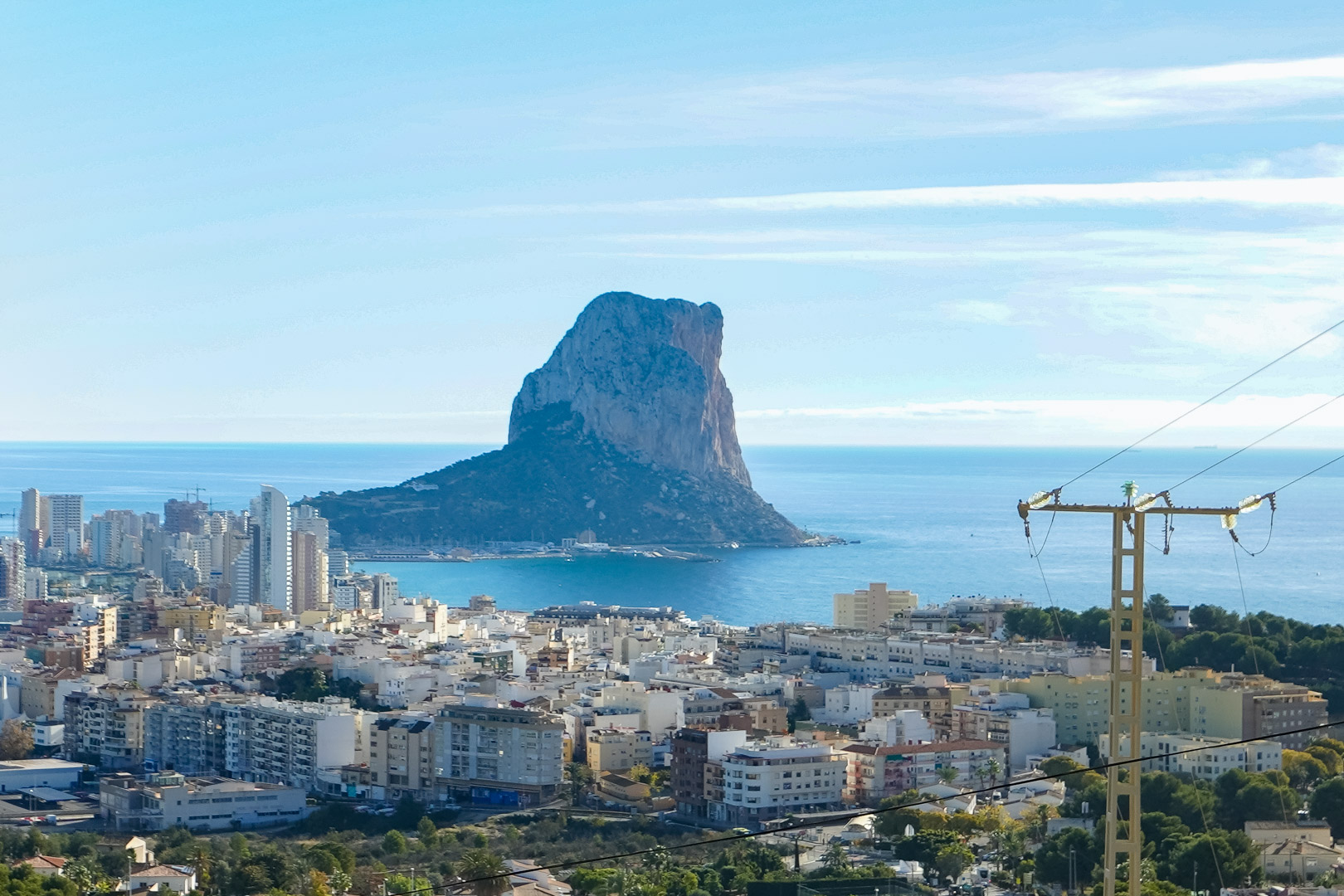 Panoramic view from the property overlooking the Peñón de Ifach, the Mediterranean Sea, and the Calpe city skyline under a clear sky.