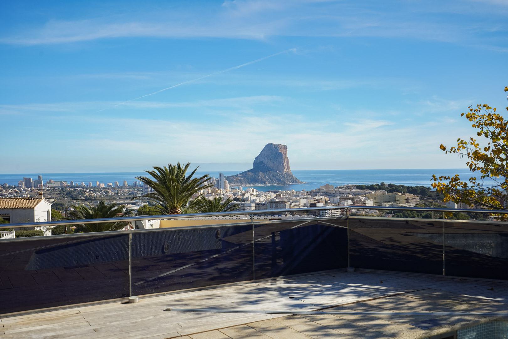 Terrace with glass and steel railing providing direct views of the Peñón de Ifach, the Mediterranean Sea, and the Calpe urban center.