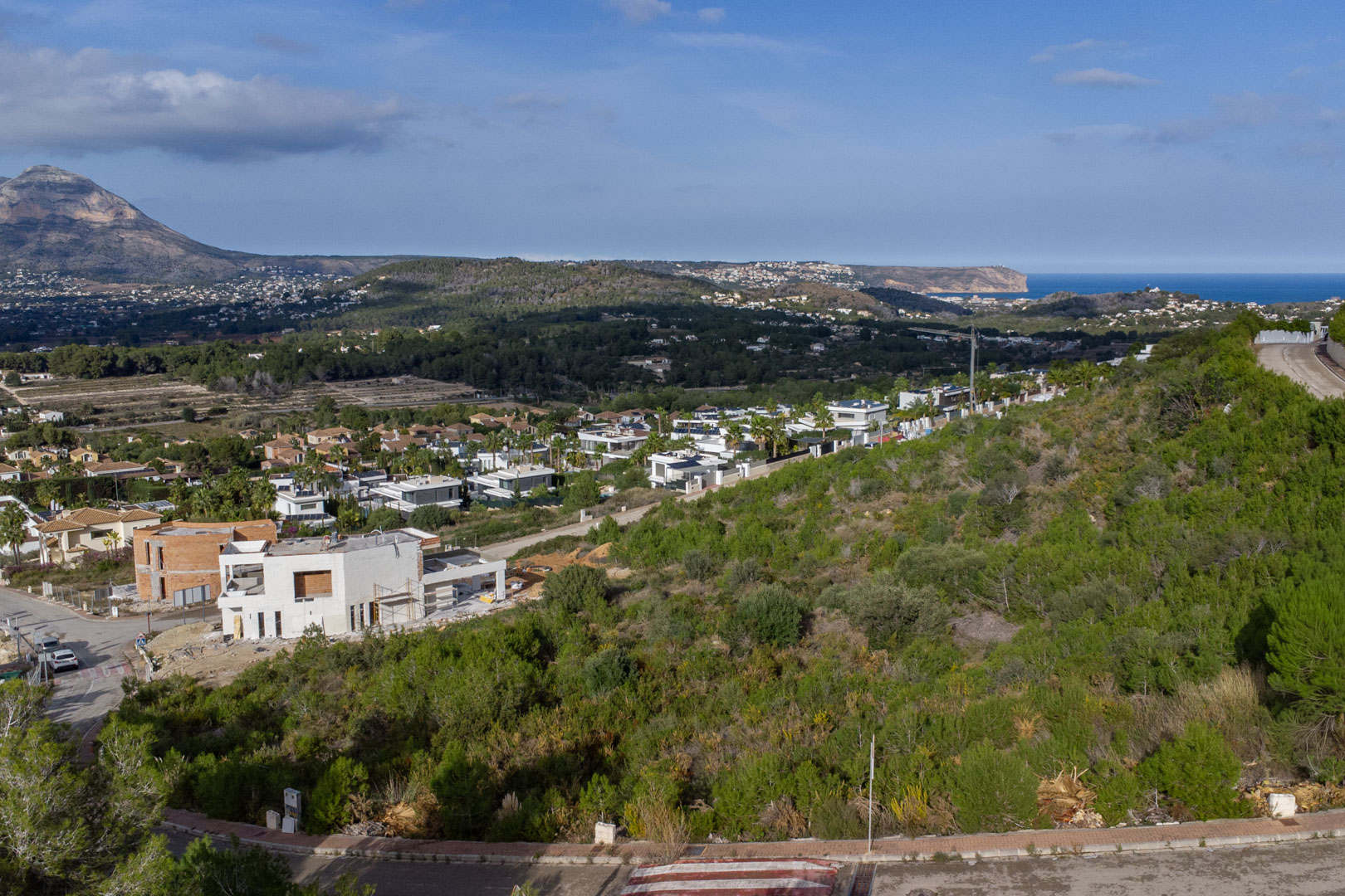 Elevated view of the Monte Olímpico plot, featuring the Montgó massif and the Mediterranean Sea with Cabo de San Antonio on the horizon.