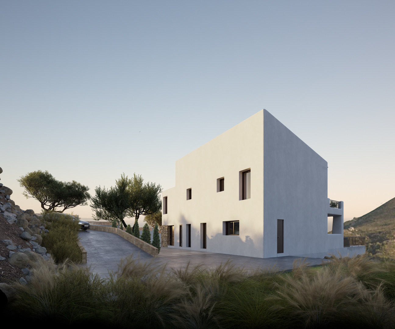 Exterior view of the Ibizan-style villa featuring a minimalist white facade, paved driveway, and natural stone walls integrated into the Alcalalí landscape.