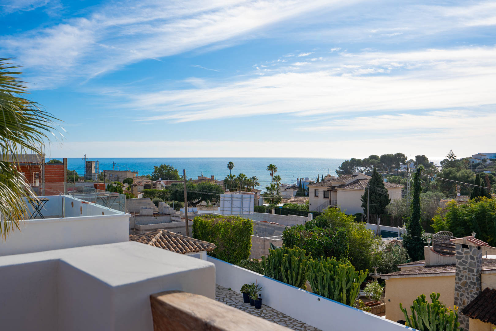 Elevated views of the Mediterranean Sea from the rooftop terrace, featuring glass balustrades and natural wood accents overlooking the coastal landscape.