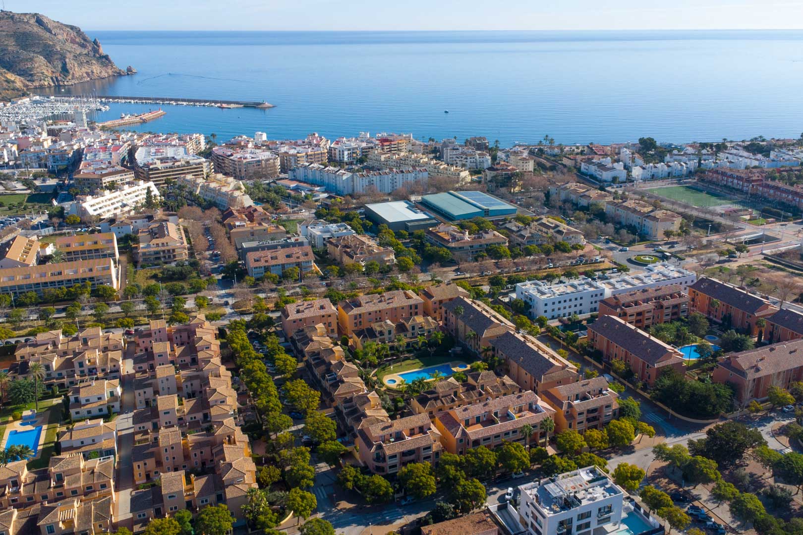 Aerial perspective of the Floridamar complex in Jávea, showcasing the central pool area and its proximity to the port and Mediterranean coastline.