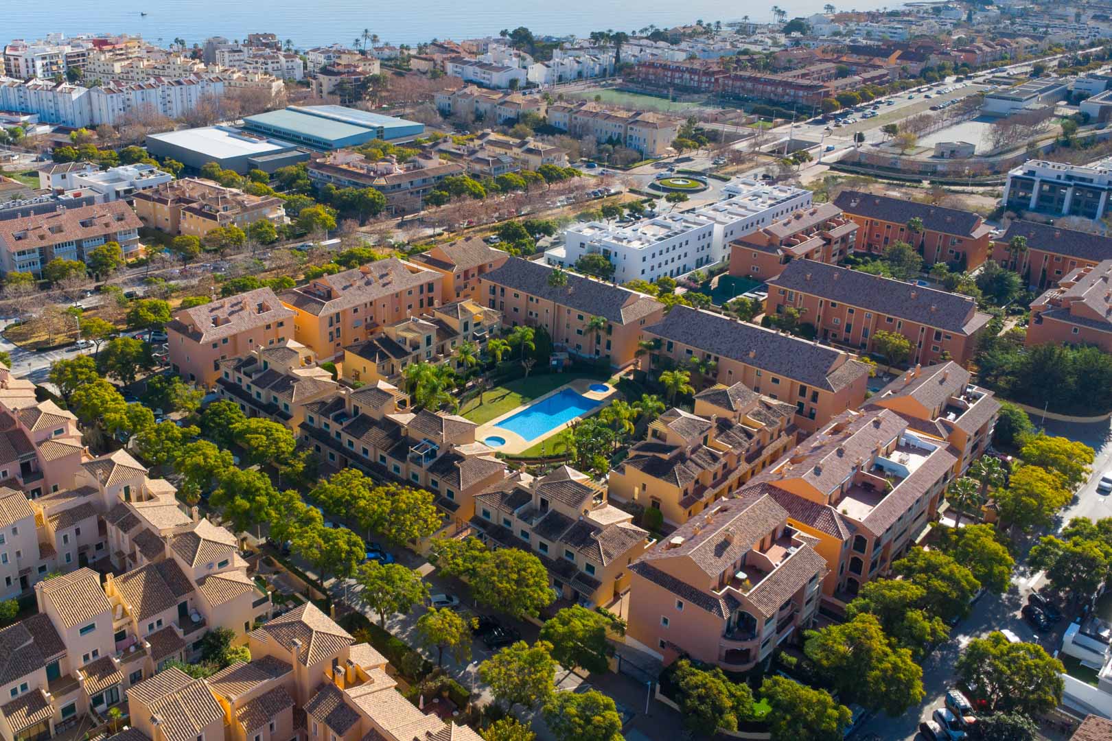 Aerial view of the Floridamar complex in Jávea, showcasing the central swimming pool, landscaped gardens, and proximity to the Mediterranean coast.