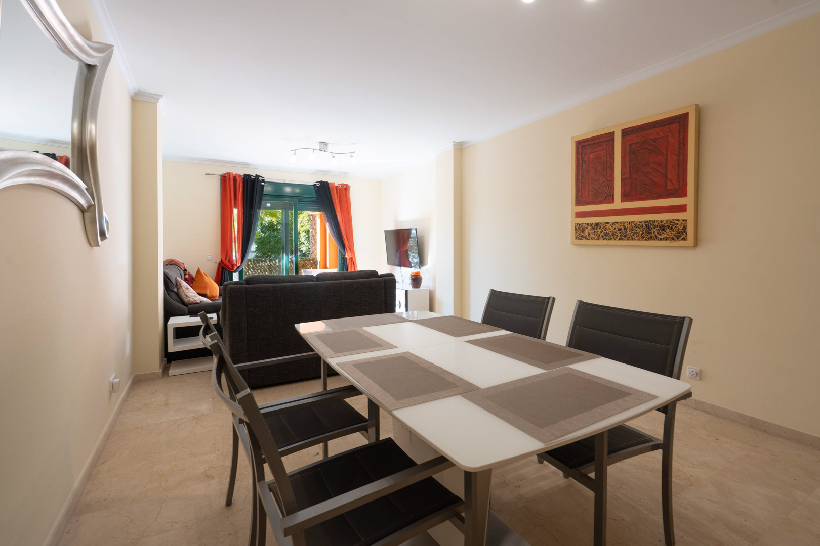 Open-plan living and dining area featuring marble flooring, contemporary furniture, and direct access to the terrace through large sliding glass doors.