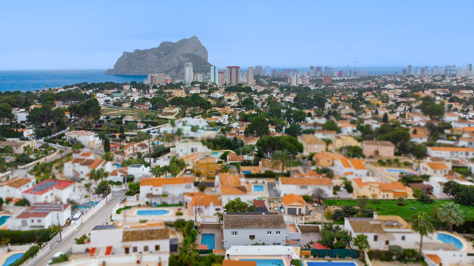 Panoramic aerial view of the Carrio residential area in Calpe, featuring the iconic Peñón de Ifach and the Mediterranean Sea in the background.