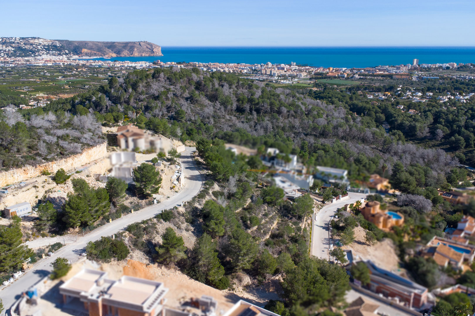 Aerial perspective of the Tosalet 5 development in Jávea, showing elevated plots integrated into the hillside with views of the Mediterranean and Cabo de San Antonio.