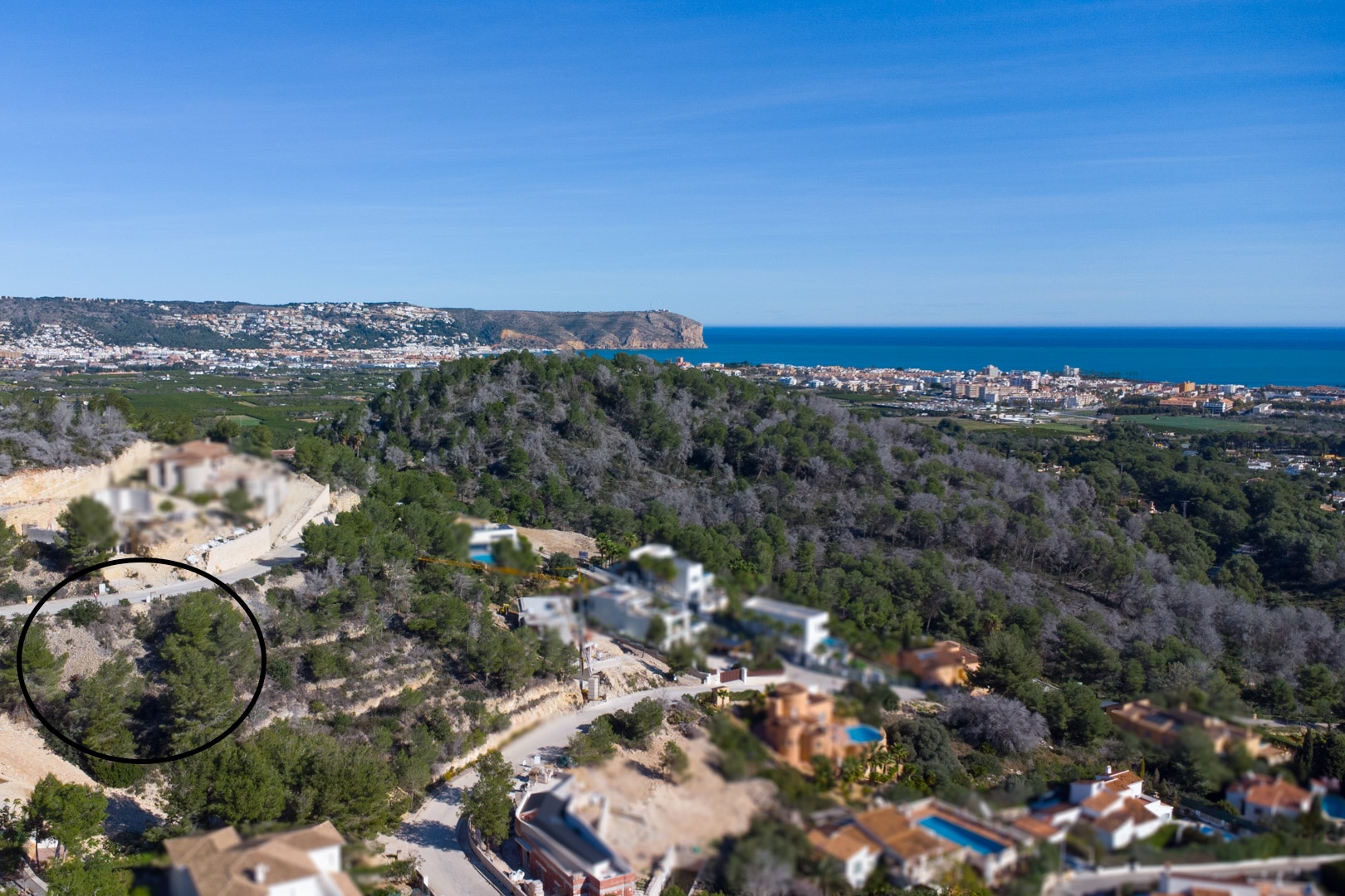 Aerial view of the elevated plot in Tosalet 5, surrounded by pine trees with panoramic views of the Mediterranean Sea and the Jávea coastline.