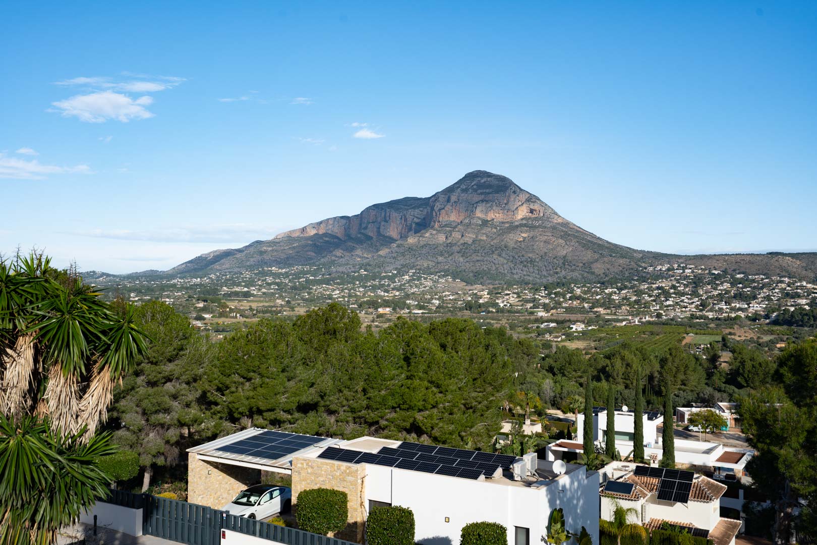 Panoramic view of the Montgó mountain from the property, featuring rooftop solar panels and a residential landscape integrated with Mediterranean pine forests.