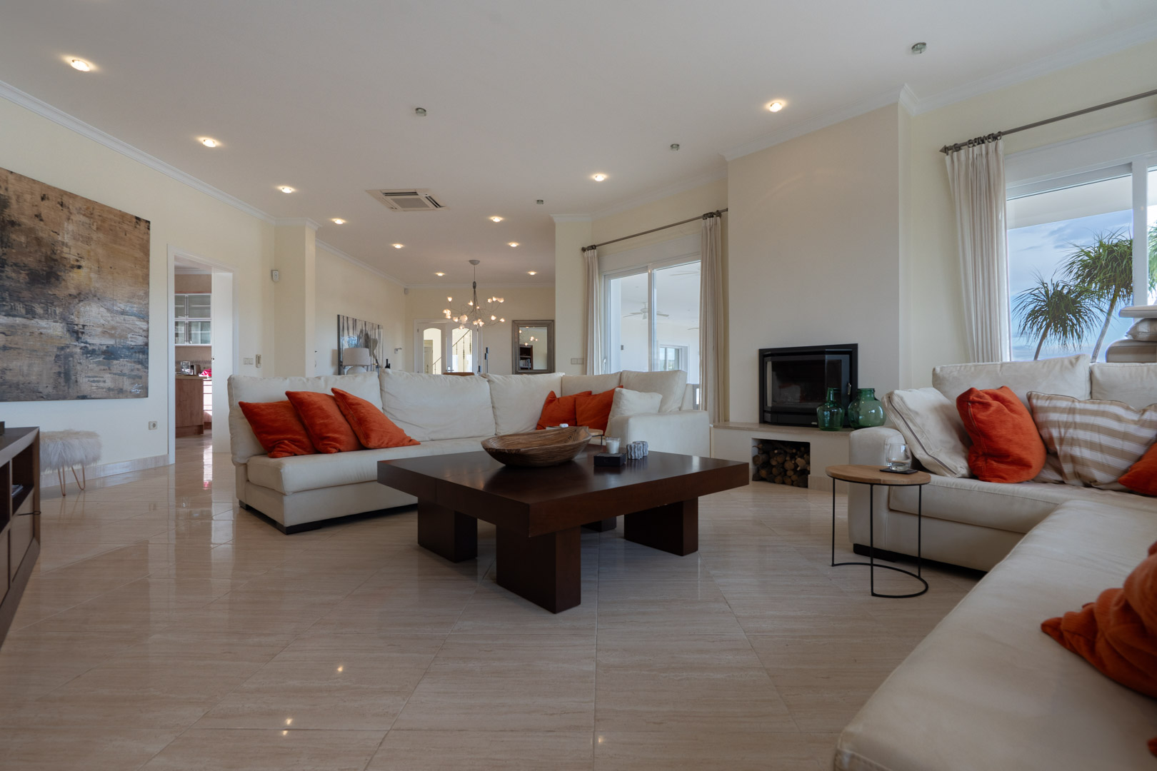 Spacious living room featuring marble flooring, a built-in fireplace, and large sliding glass doors that provide direct access to the terrace.