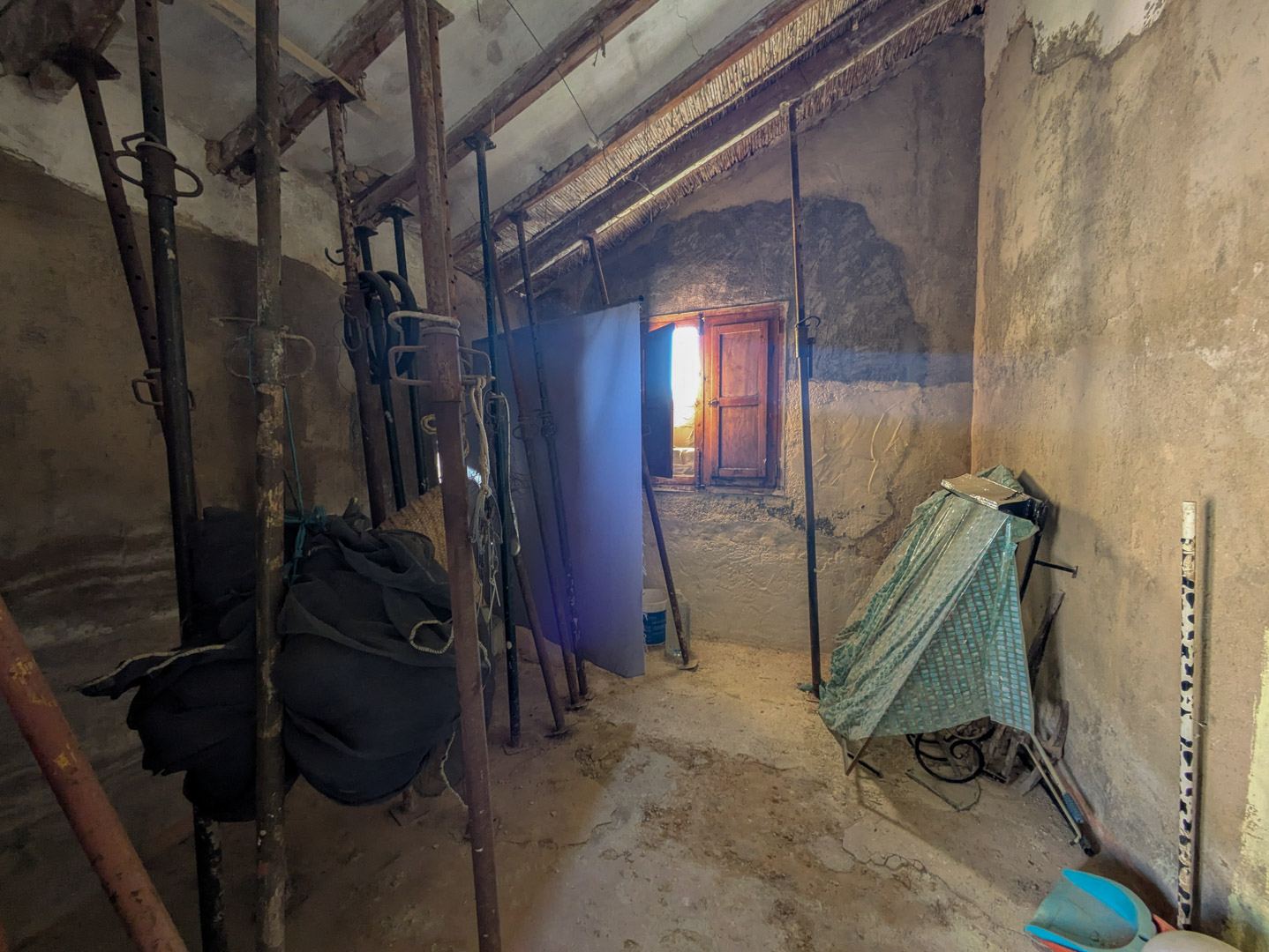Interior space featuring traditional reed and timber ceilings supported by metal props, showcasing the structural potential for a complete renovation project.