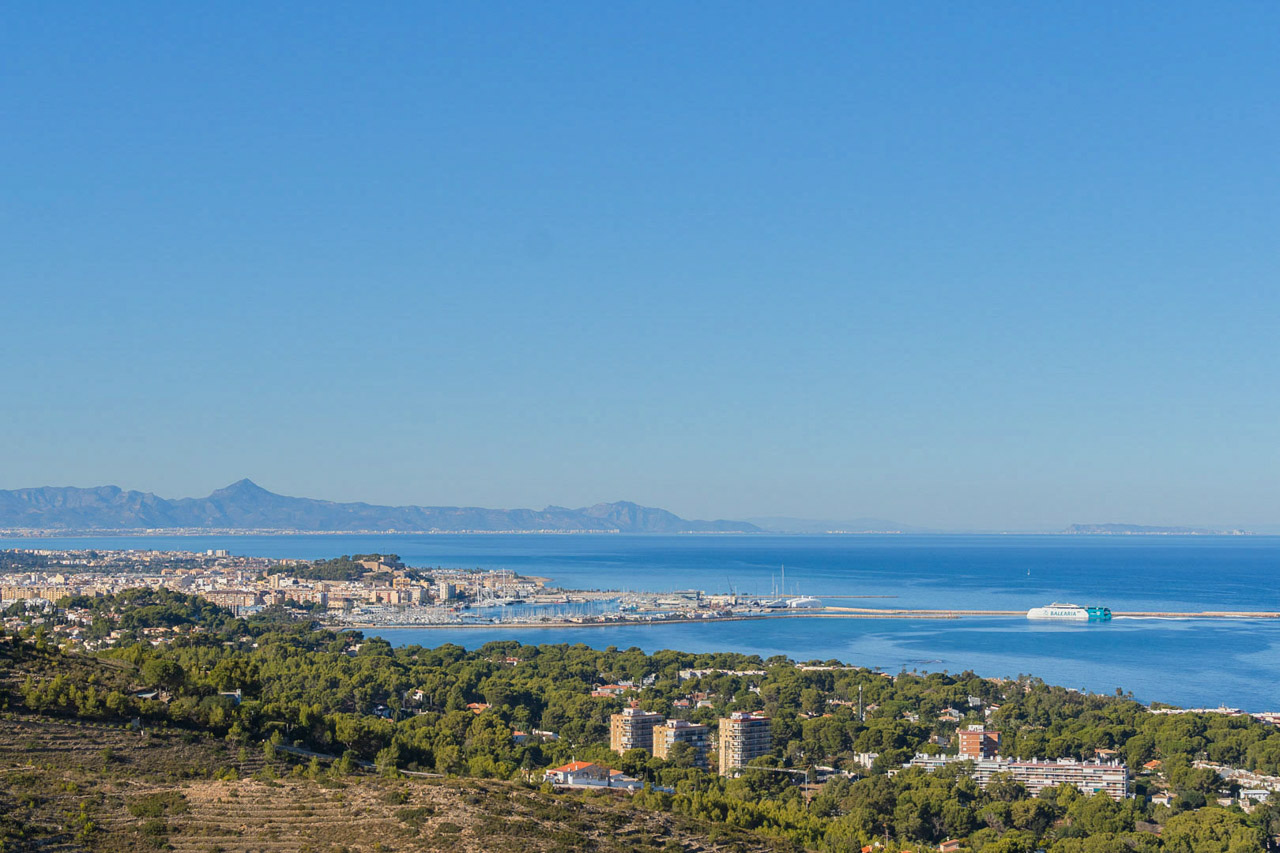 Panoramic view from the property overlooking Dénia's port and the Mediterranean Sea, featuring the historic castle and the coastline under a clear blue sky.