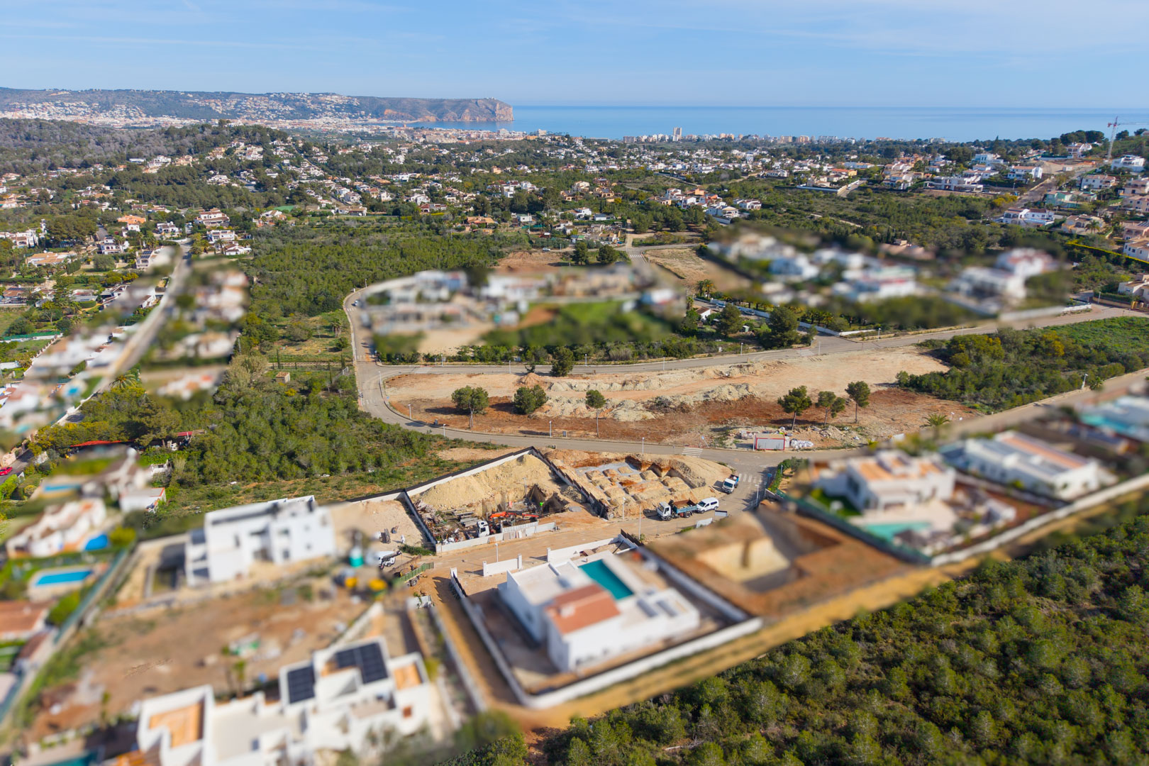 Aerial view of the construction plot in Valsol, Jávea, showing the foundation phase and panoramic views of the Mediterranean coastline and horizon.