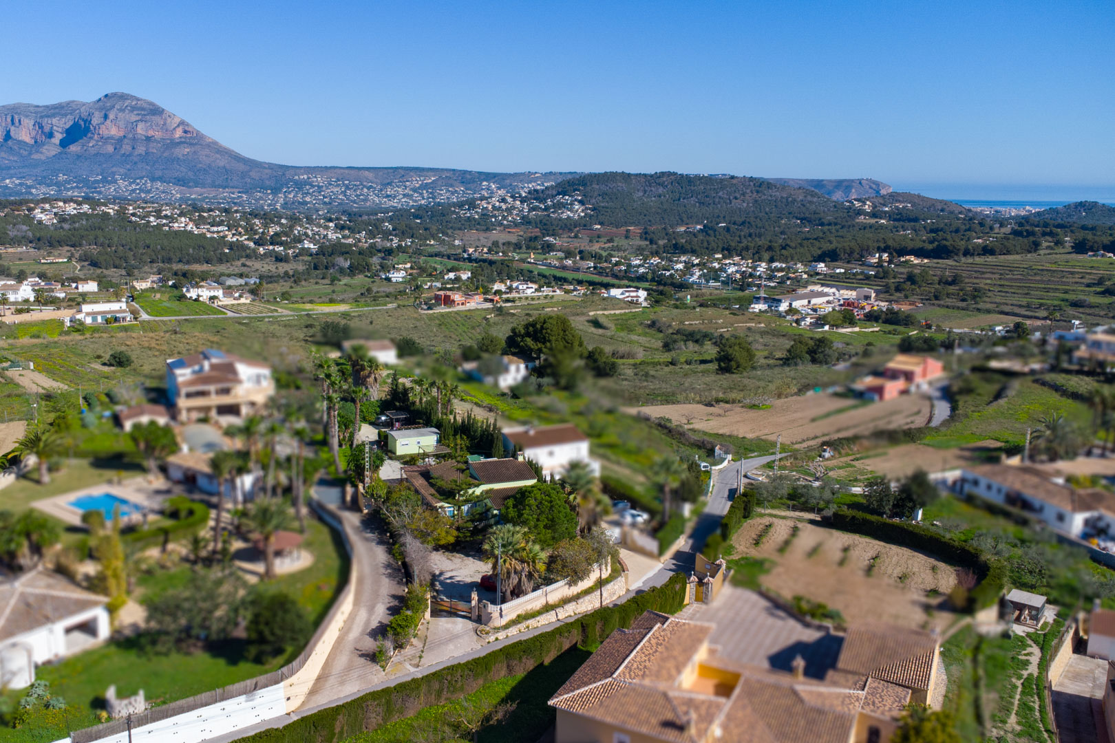 Aerial perspective of the traditional finca and rustic plot, showcasing panoramic views of the Montgó mountain and the Mediterranean coastline.