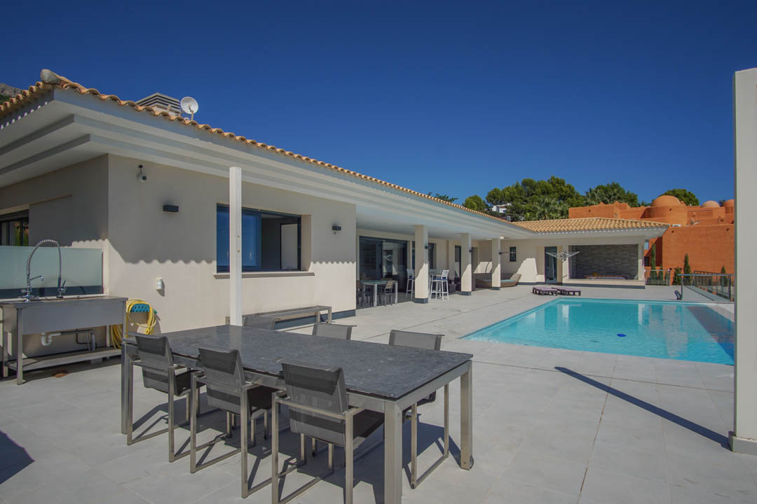 Expansive 240sqm terrace featuring a 10x4m swimming pool, outdoor dining area, and a functional summer kitchen with a stainless steel workstation.