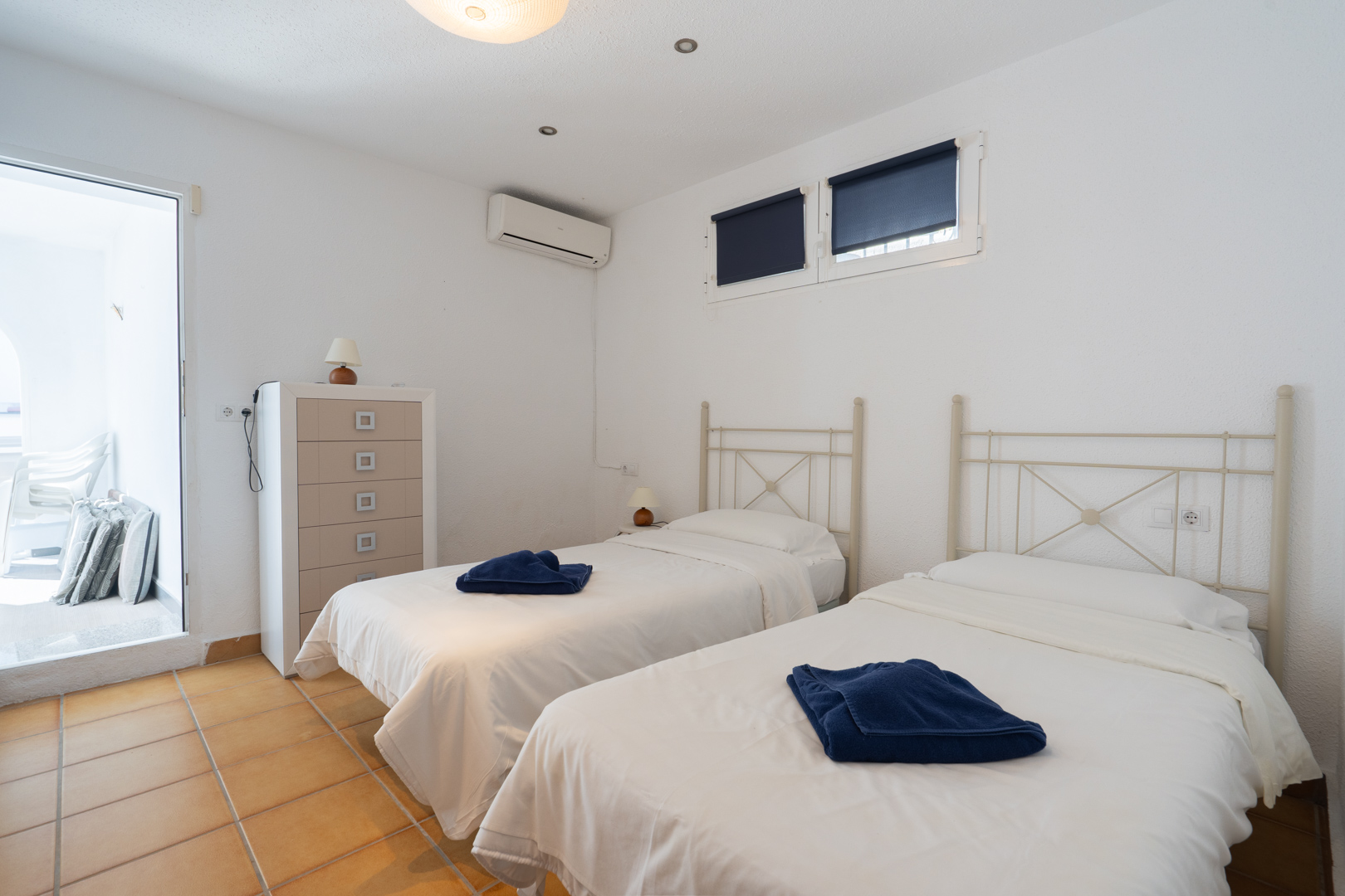 Bedroom featuring twin beds, terracotta tile flooring, and air conditioning. Includes direct access to the terrace and plenty of natural light.