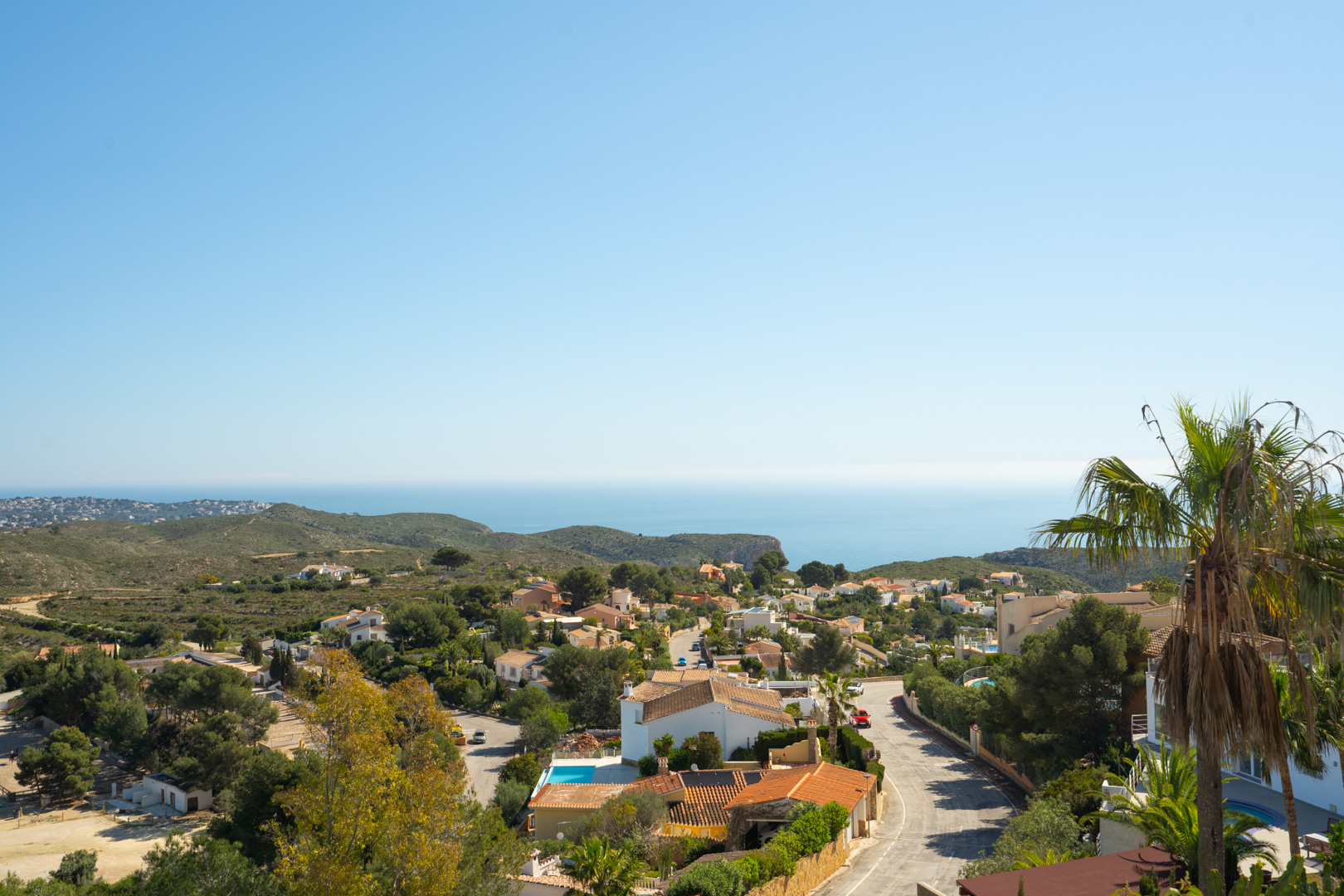 Panoramic views from the property overlooking the Cumbre del Sol residential area, the Mediterranean Sea, and surrounding green hills.