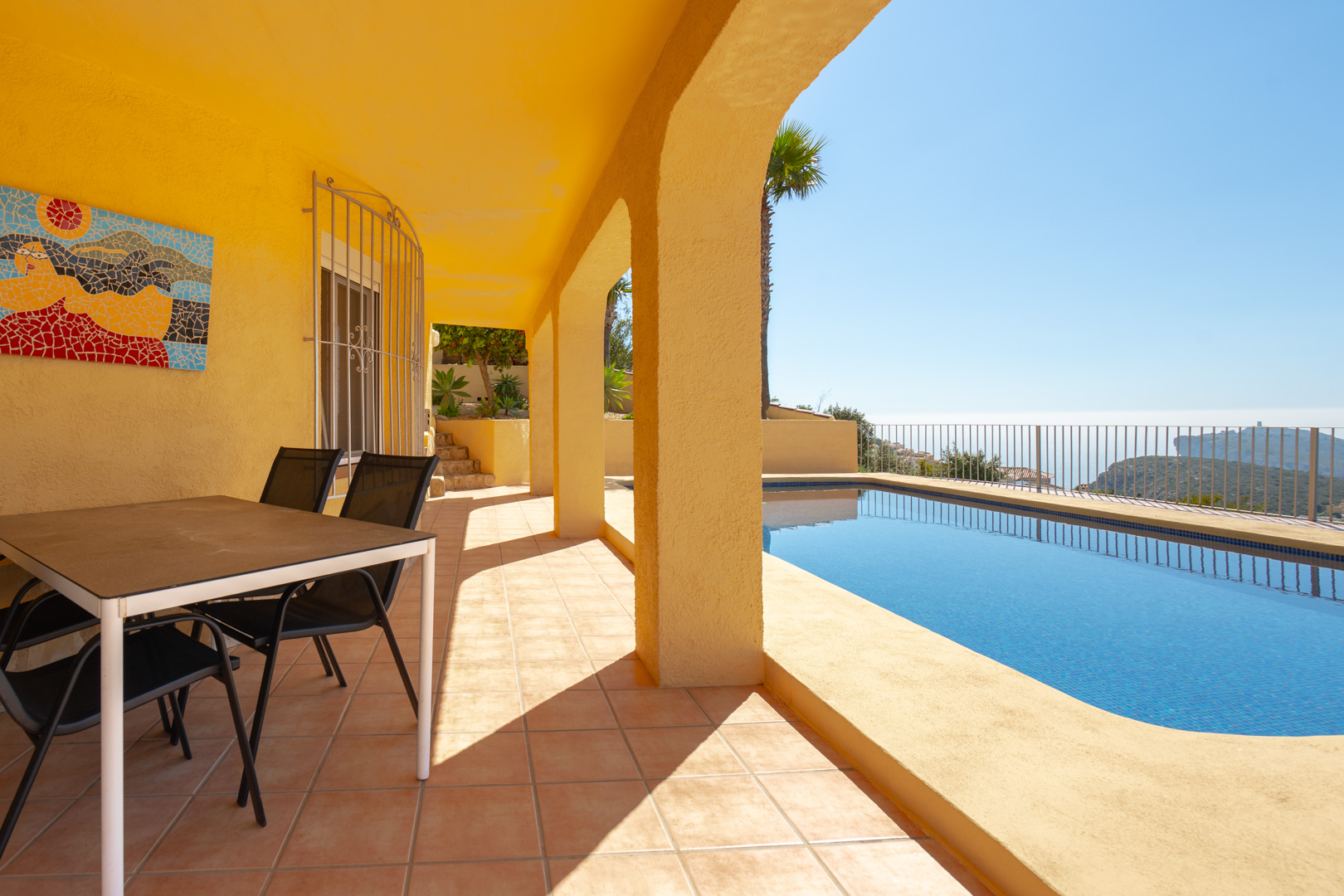 Covered terrace featuring traditional arches, outdoor dining space, and a private pool with panoramic views of the Mediterranean and Cap d'Or.
