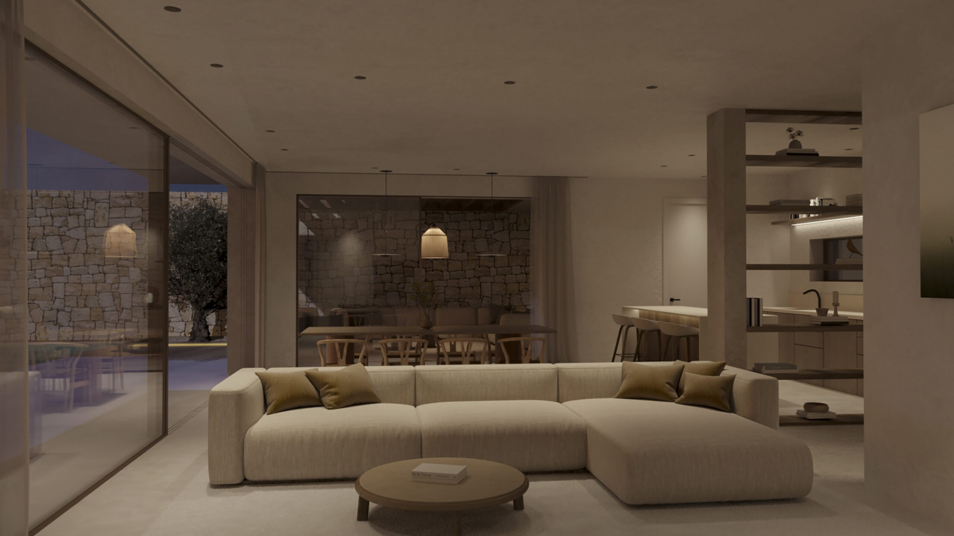 Open-plan living and dining area featuring a modular sofa, round coffee table, and sliding doors to a stone-walled terrace with an olive tree. Integrated kitchen visible.