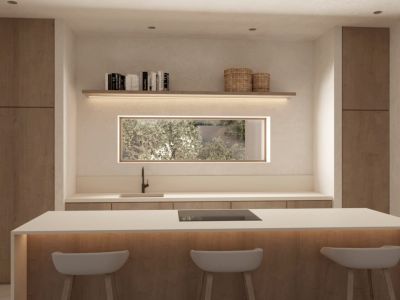 Modern kitchen island with integrated hob, white countertop, and three bar stools. Features wooden cabinetry, a rectangular window with garden views, and backlit shelving.