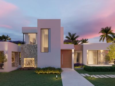 Modern villa facade at twilight featuring striking white walls, natural stone cladding, a wooden entrance door, and illuminated garden path with water feature.