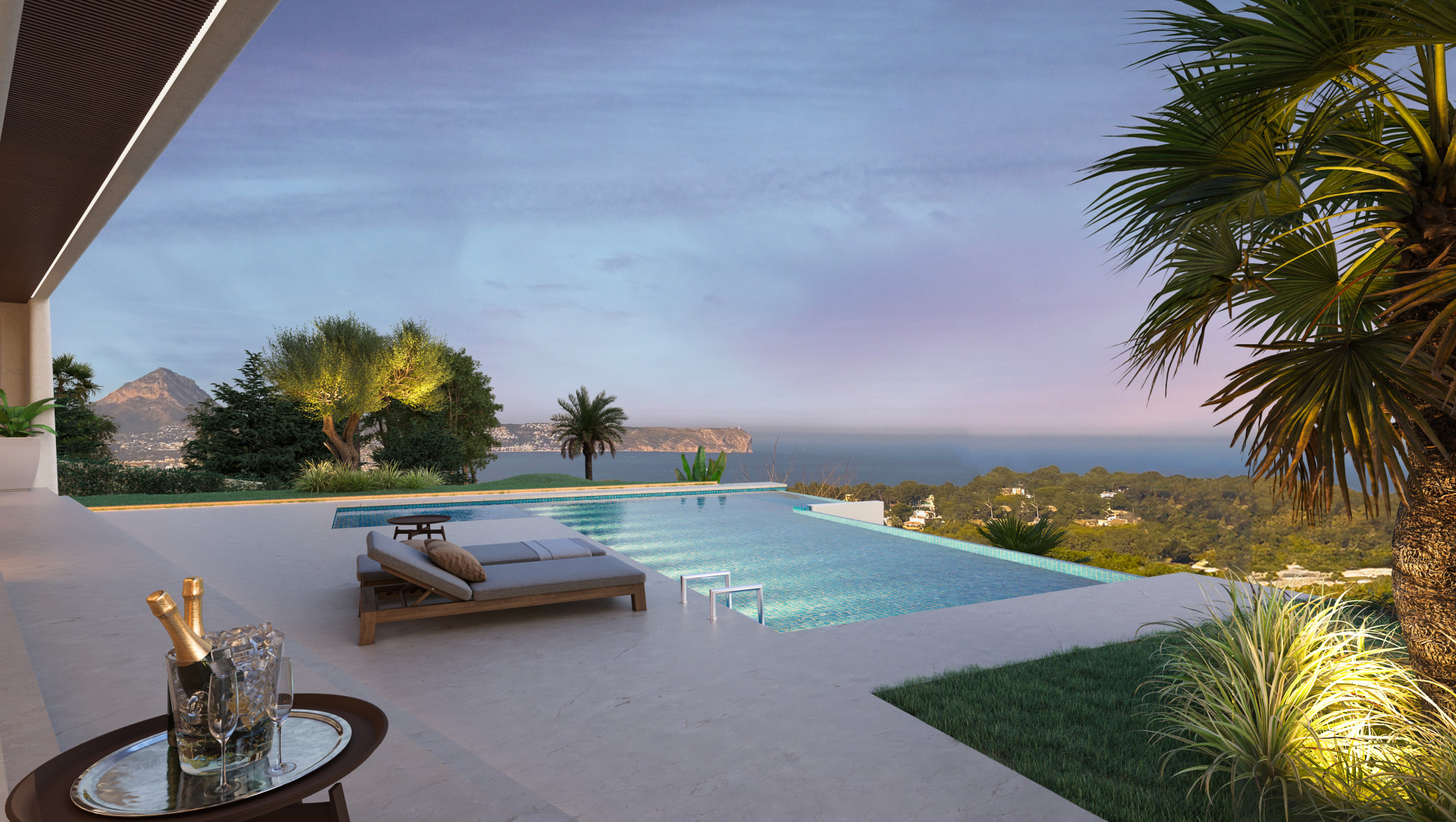 View of the infinity pool with sunbeds, garden, and sea and mountain views at sunset in Jávea.