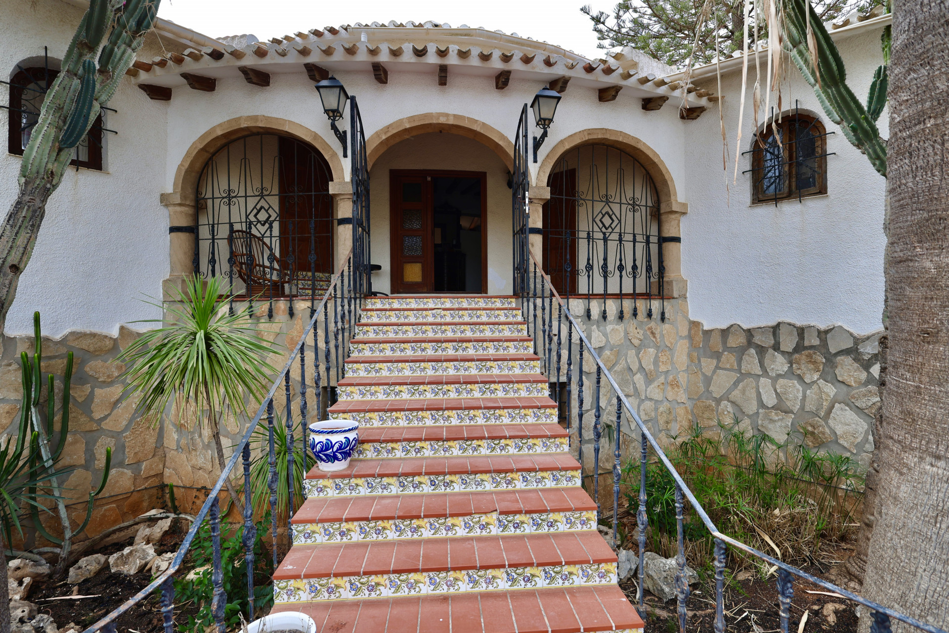 Main entrance of the villa featuring terracotta steps with floral details.
