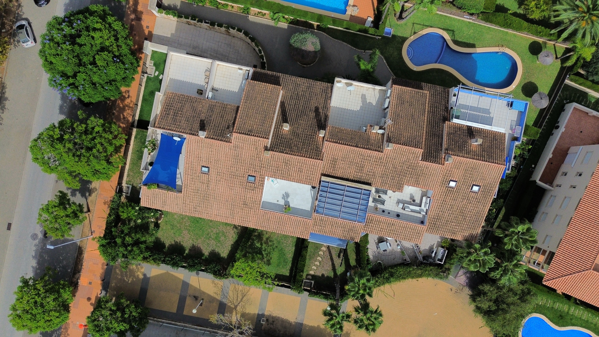 Aerial view of the duplex penthouse featuring terraces, pool, and lush gardens.