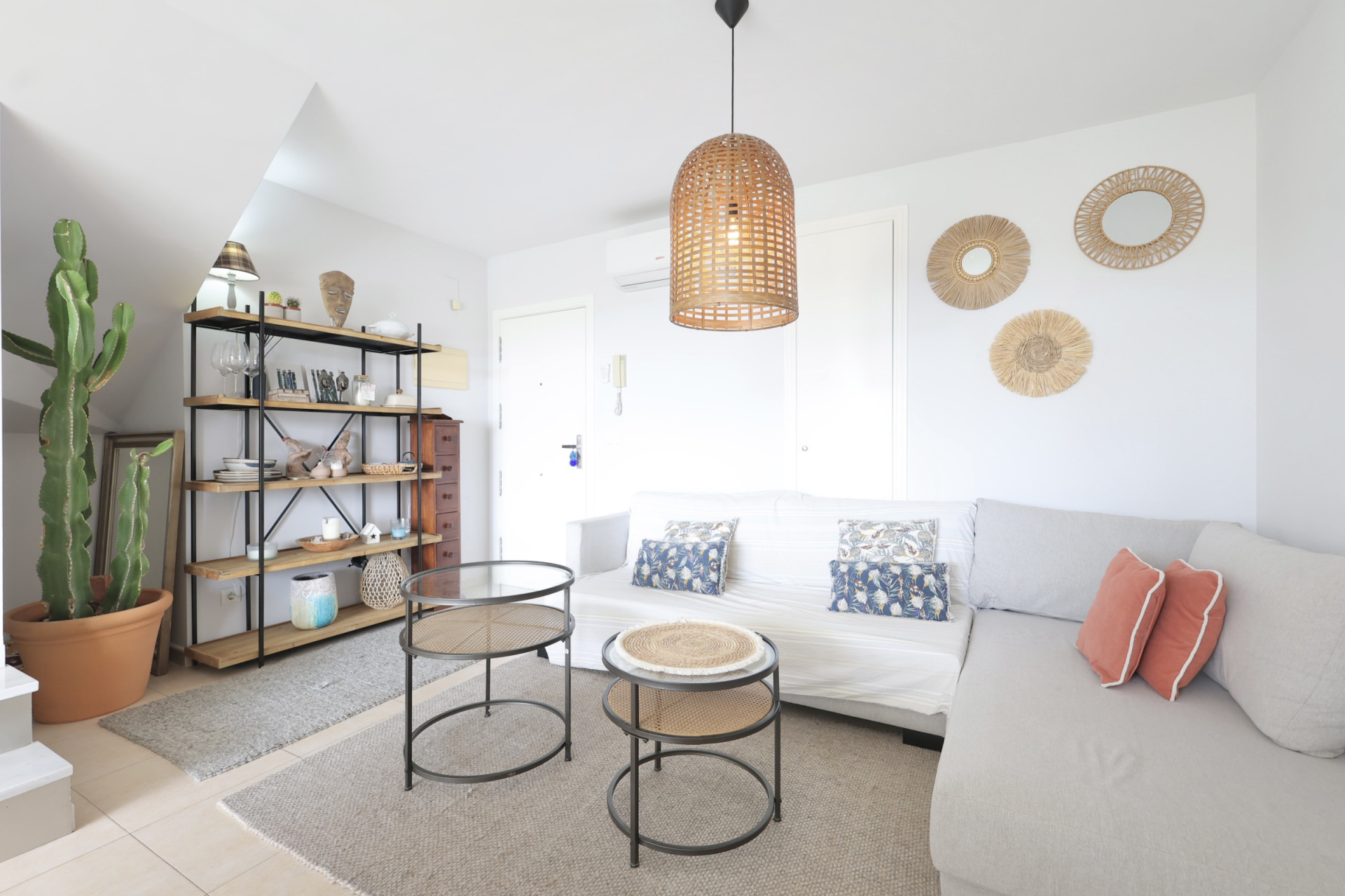 Bright living room featuring a wooden shelf, modular sofa, and designer side tables.