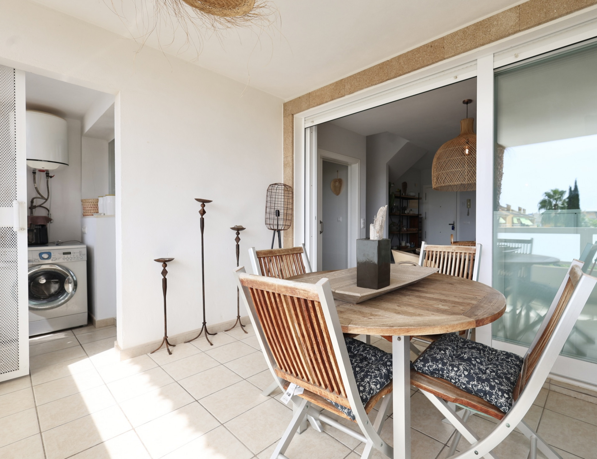 Terrace featuring a round wooden table and matching chairs, with access to a laundry room.