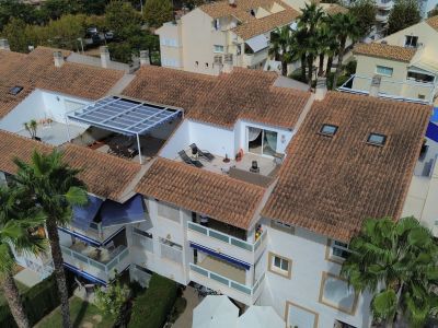 Aerial view of the duplex penthouse featuring a sun terrace, awning, and terracotta roof tiles in Jávea.