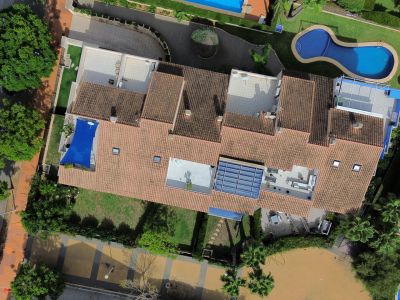 Aerial view of the duplex penthouse featuring terraces, pool, and lush gardens.
