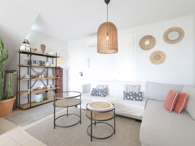 Bright living room featuring a wooden shelf, modular sofa, and designer side tables.