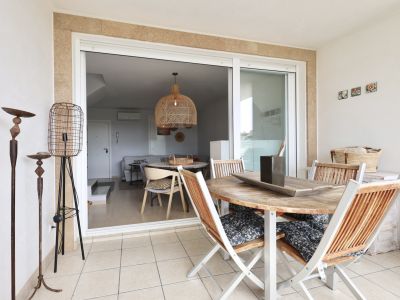 Covered terrace featuring a wooden table and foldable chairs with patterned cushions.